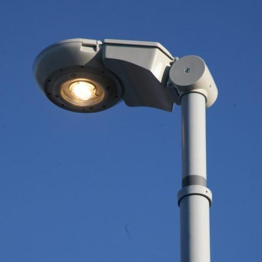 Moderní pouliční lampa, která umožňuje variabilní sklon svítidla. 27 Svítidlo LED Synchro v odstínech šedé barvy na pozadí modré oblohy.